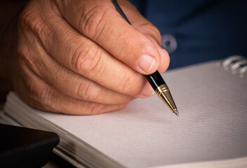 Male hand with pen signing on blank sheet