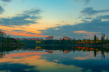 Landscape of a lake surrounded by buildings and lights in the evening in Chisinau, Moldova