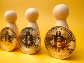 Peg doll and bitcoin on a yellow background with copy space.