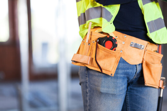 construction site worker wearing velt with tools