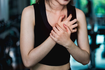 Woman injury pain chest attack heart after workout training exercise at fitness gym