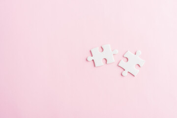 Top view flat lay of two paper plain white jigsaw puzzle game last pieces for solve, studio shot on...