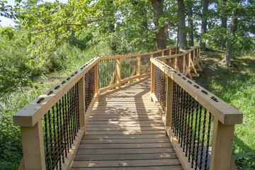 Beautiful wooden boardwalk through the dense vegetation on a sunny day