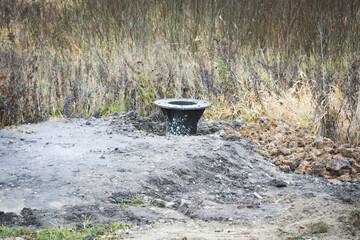 Base for a new metal pole for street lighting. A post buried in the ground, installation of a new...