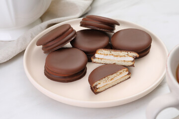 Plate with delicious choco pies on white table, closeup