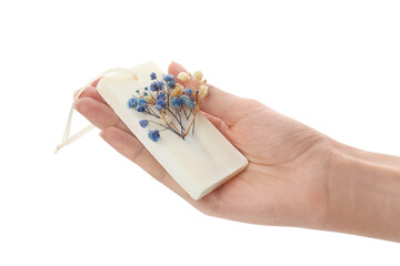 Woman holding scented sachet with flowers on white background, closeup