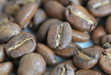 Close up view of roasted arabica coffee beans on a blurred coffee background
