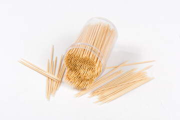 Wooden toothpicks and holder on white background