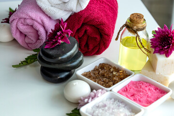 Obraz na płótnie Canvas Towel in roll shape with Himalayan pink salt stack of black stone and aroma oil put on bed,prepare to use spa room.