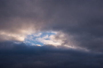 The blue sky looks out among the dark winter clouds