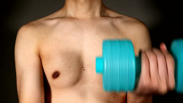ダンベル運動をする裸の日本人男性