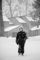 Fototapeta na wymiar Boy in black walking in a snowy day 