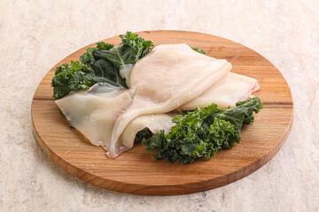 Raw squid over wooden board