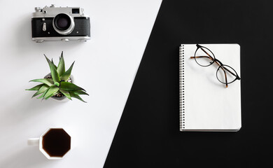 Vintage camera, coffee cup, glasses and notepad, flat lay.