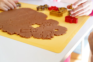 Selective focus. Kids making gingerbread cookies with various Christmas cookie cutters. Gingerbread dough. Family Christmas moments