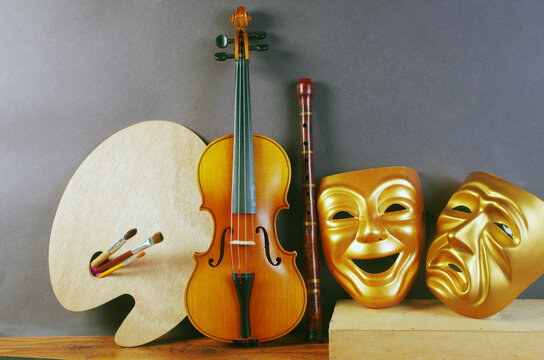 Attributes of the arts. Painting, music, theater. Art palette, brushes, violin, theater masks 