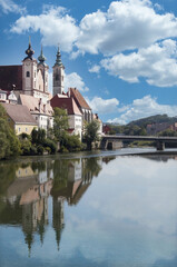 Fototapeta na wymiar View of Österreichisches Weihnachtsmuseum and its reflection in the Steyr river from Museumssteg bridge.