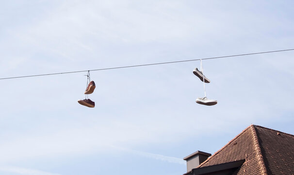 Two pairs of sneakers hanging by its laces on cables of the street lighting in Steyr, Austria.