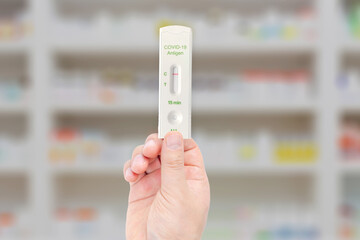 A person holding a Covid-19 Rapid test at pharmacy