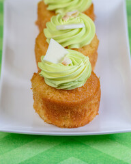 A lemon and lime cupcake on a white and green background with white chocolate