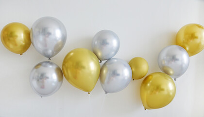 Shiny golden and silver balloons arrangement on the wall