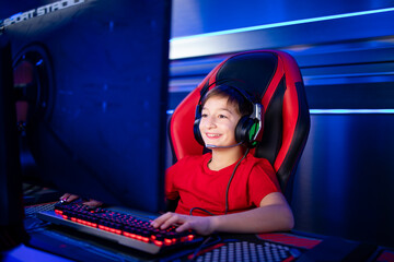 Professional gamer with headset playing or streaming online video games on computer. Children addicted to entertainment industry. © littlewolf1989