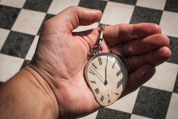 No time to lose concept. Vintage pocket watch melting in a hand. 