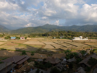 Rice field with mountains and blue sky background in Doi Sakard, Mueang Nan district, Nan, Thailand.
