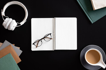 Open blank notebook on black background, flat lay.