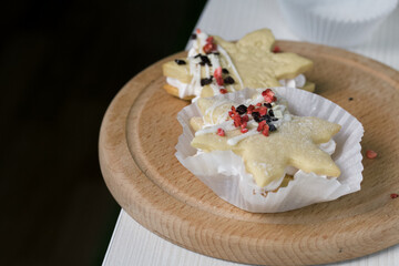 Marshmallow sandwiches decorated with chocolate and freeze-dried strawberries. Lie on a round wooden board. Close-up shot.