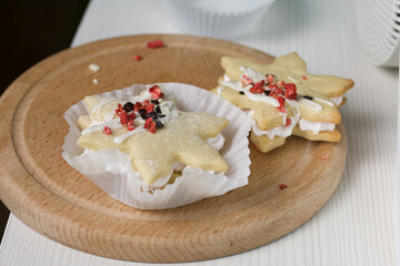 Marshmallow sandwiches decorated with chocolate and freeze-dried strawberries. Lie on a round wooden board. Close-up shot.