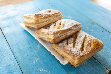 Puff pastry apple pastry turnovers for dessert on a wooden table