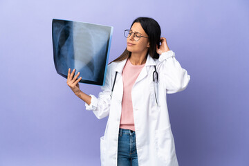 Young doctor woman holding a radiography having doubts