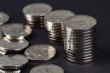 Ukrainian 10 hryvnias coins. Money and finances. Stack of 10 hryvnia coins, on a dark background. Ukrainian coins