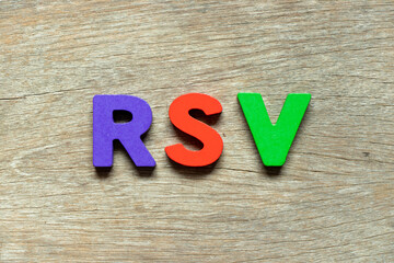 Color alphabet letter in word RSV (Abbreviation of Respiratory syncytial virus) on wood background