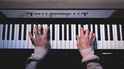 Close-up of male hands playing the piano keys.