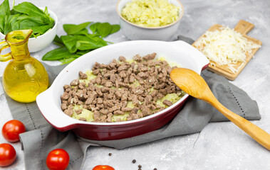 putting minced meat in the potato casserole