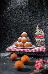 balls donuts with powdered sugar on red napkin and christmas decoration