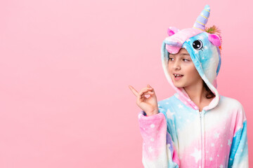 Little caucasian woman wearing a unicorn pajama isolated on pink background intending to realizes the solution while lifting a finger up