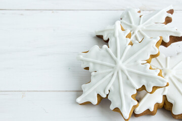 Christmas gingerbread. Close-up. Gingerbread cookies in white glaze on a light wooden background. Christmas traditions. Copy space. - 475834864
