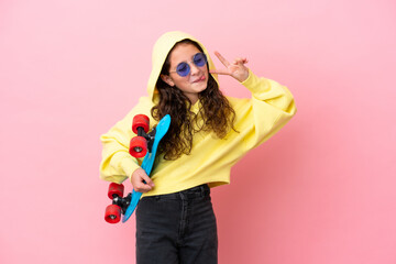 Little caucasian girl isolated on pink background with a skate with happy expression © luismolinero