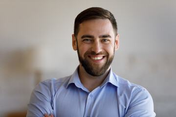 Head shot portrait of smiling confident young bearded man, posing indoors, real estate ownership....