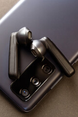 Wireless black headphones on the phone case, the concept of a gift to a loved one.