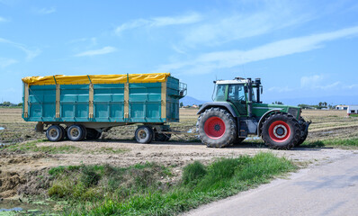 Obraz premium Farm tractor with trailer in the field
