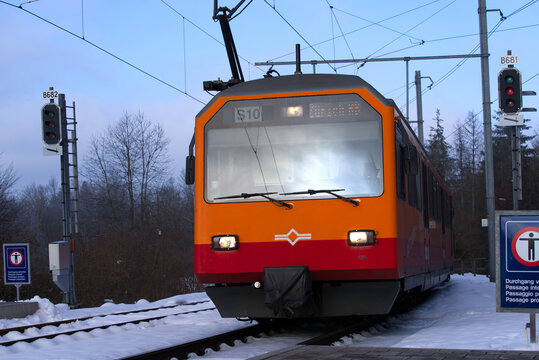 Orange and red SZU train at railway station of local mountain Uetliberg on a cold and foggy winter day. Photo taken December 18th, 2021, Zurich, Switzerland.