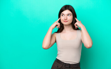 Young Russian woman isolated on green background having doubts and thinking