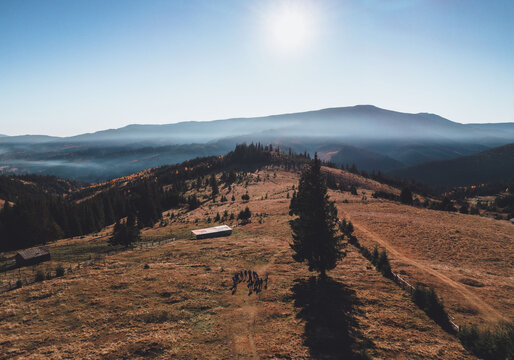 Aerial Shot Of A Group Of People Standing On A Dry Ground Over A Mountain