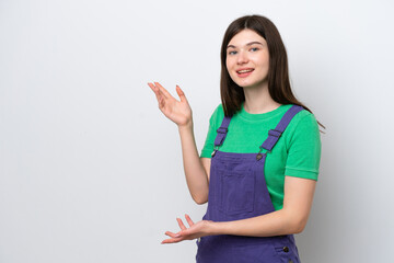Young Russian woman isolated on blue background extending hands to the side for inviting to come
