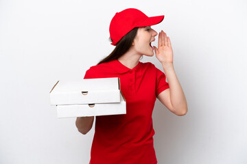 Young Russian pizza delivery picking up pizza boxes isolated on white background shouting with...