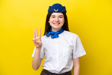 Airplane stewardess Russian woman isolated on yellow background happy and counting three with fingers